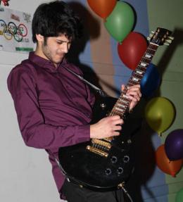 Kiran Eyre playing guitar at the hustings