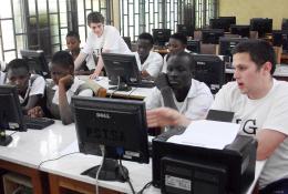 Matthew Baldwin (right) and Jonathan Moon (centre, back), introduce Ghanaian students to their software learning packages in Aburi.